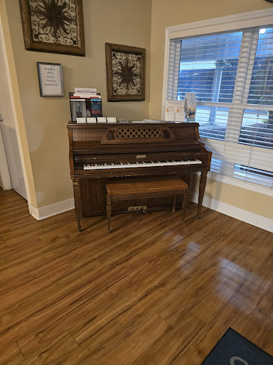 A beautiful wooden piano placed in a well-lit room, enhancing the home's ambiance.