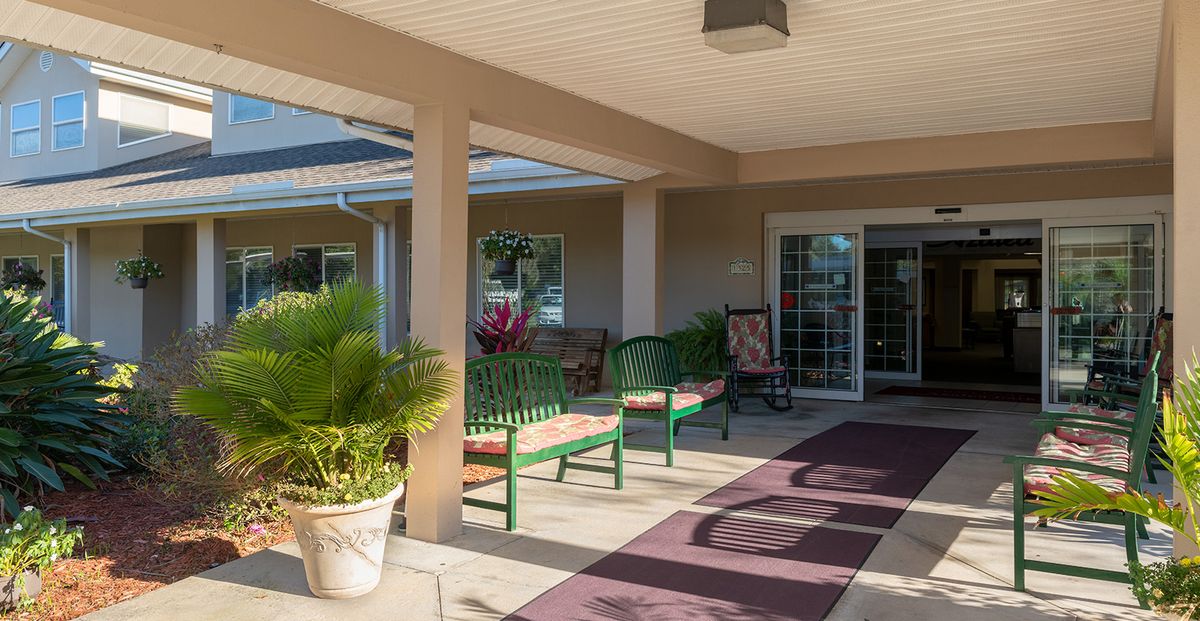 A welcoming porch area with benches and potted plants.