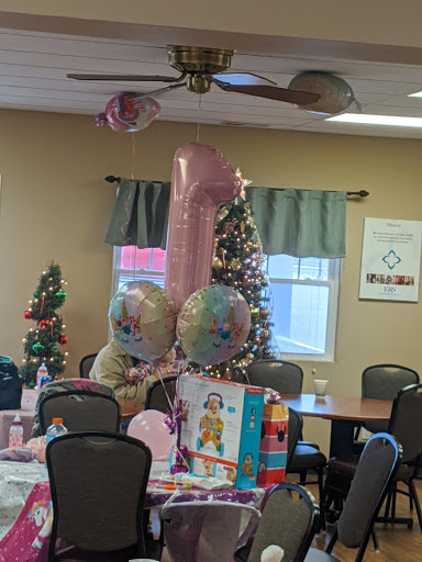 A festive birthday celebration setup featuring a pink number one balloon, colorful decorations, and gifts, all in a warm, inviting room.