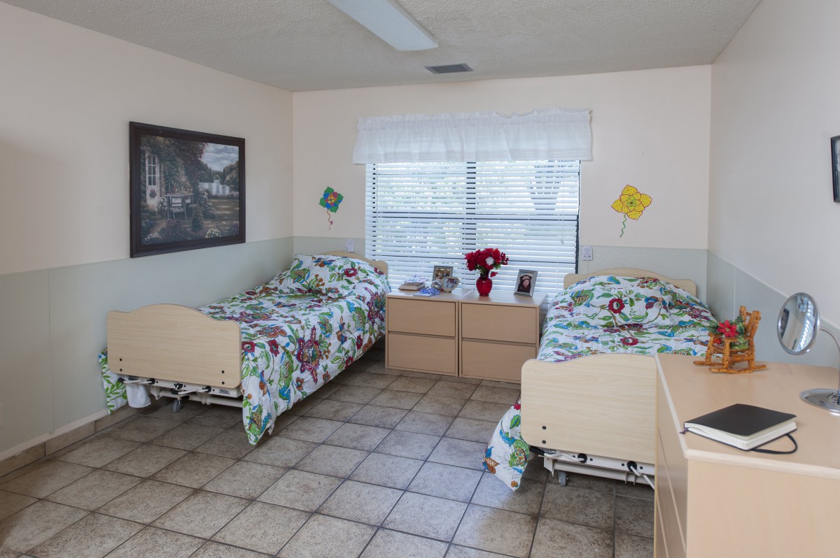 A shared hospital room with two beds, bright decor, and a window.