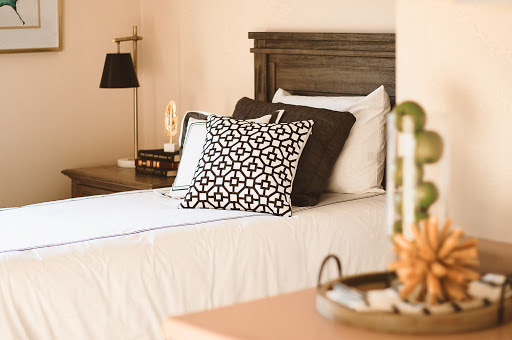 A cozy and stylish bedroom setup featuring patterned pillows and elegant furnishings.