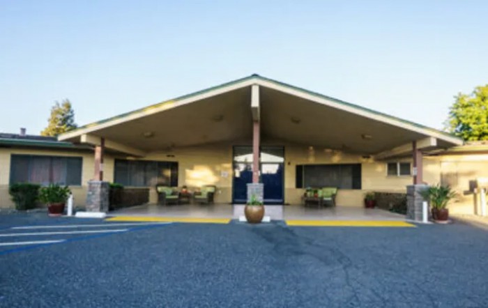 Exterior view of a motel with a distinctive triangular roof and parking area.