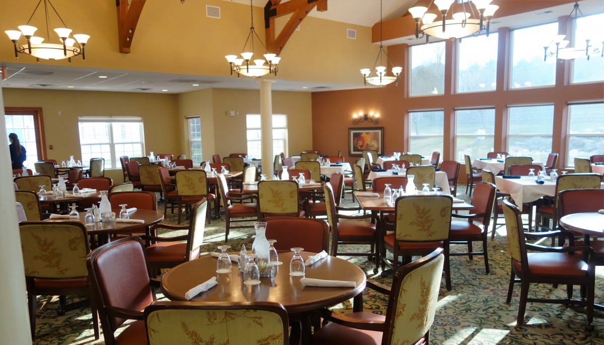 An elegant dining area set up with tables and chairs, ready for guests.