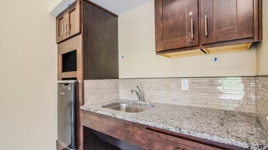 A modern kitchen with a sink and granite countertop.