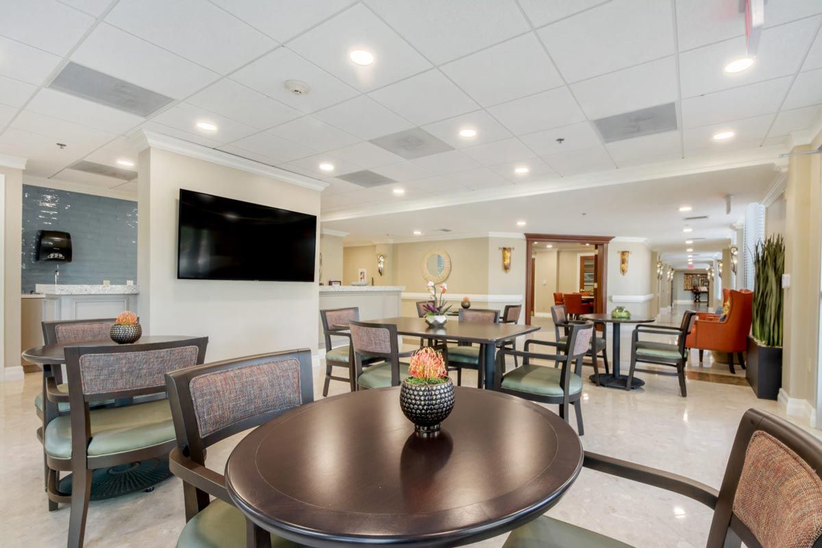 A modern hotel lobby with comfortable seating and a large television.
