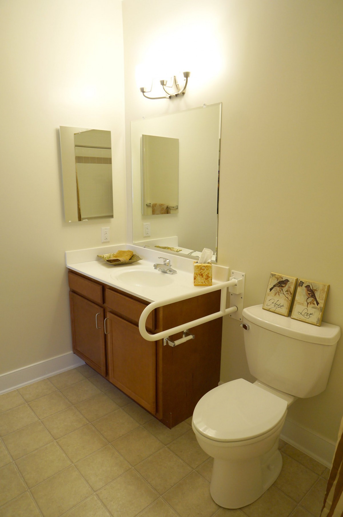 A small bathroom with a sink, mirror, and toilet.