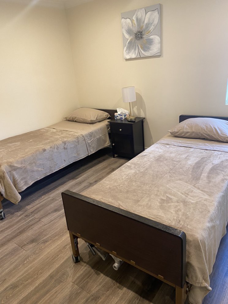 A minimalist bedroom with two twin beds and a nightstand.