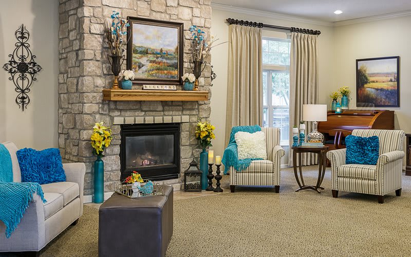 A cozy living room with a stone fireplace and comfortable seating.