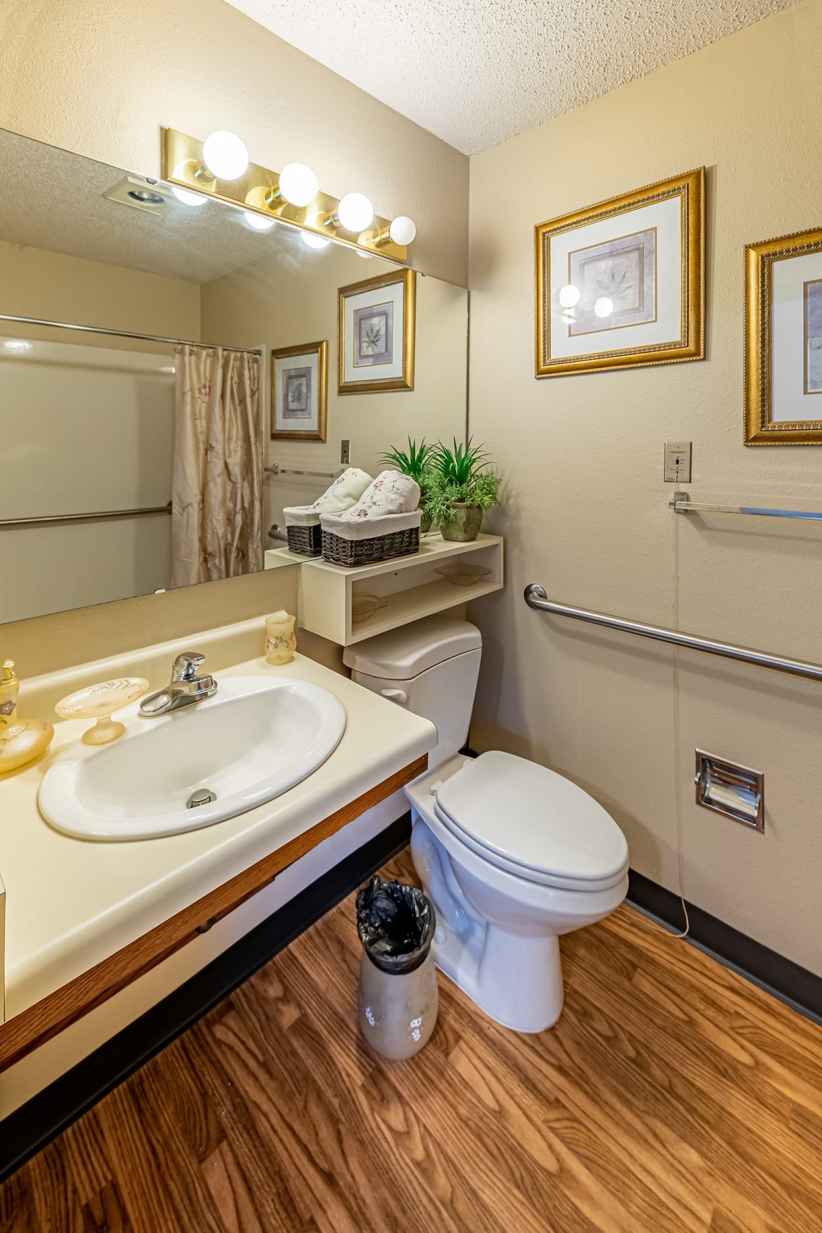 A well-organized bathroom with a sink, toilet, shower, and stylish decor.
