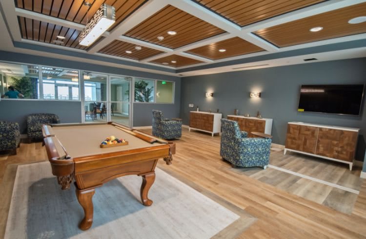 A modern game room featuring a pool table and comfortable seating.