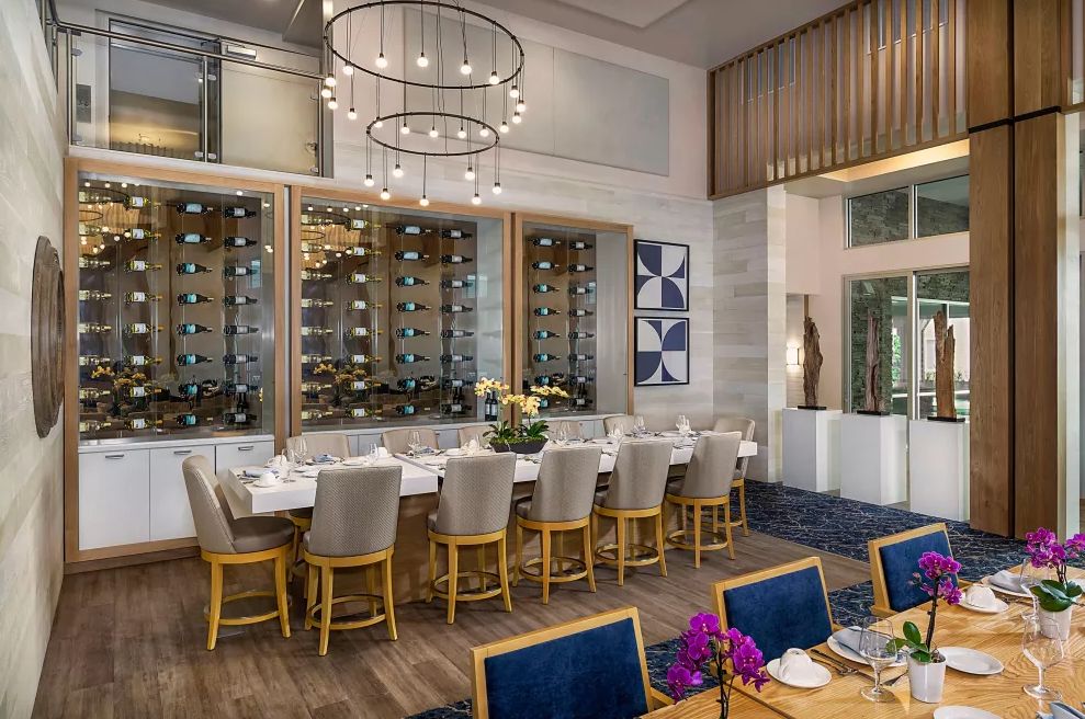 Elegant dining space with a modern wine display and luxurious seating.