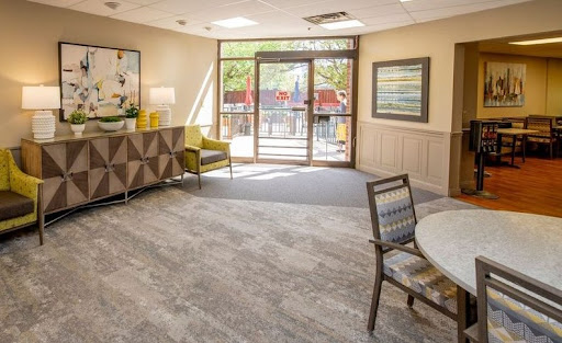 A bright and inviting lobby space featuring modern furniture and large windows.