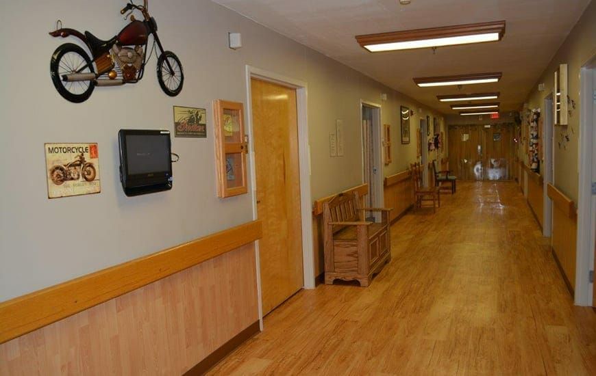 A hospital hallway with wooden flooring and seating along the sides.