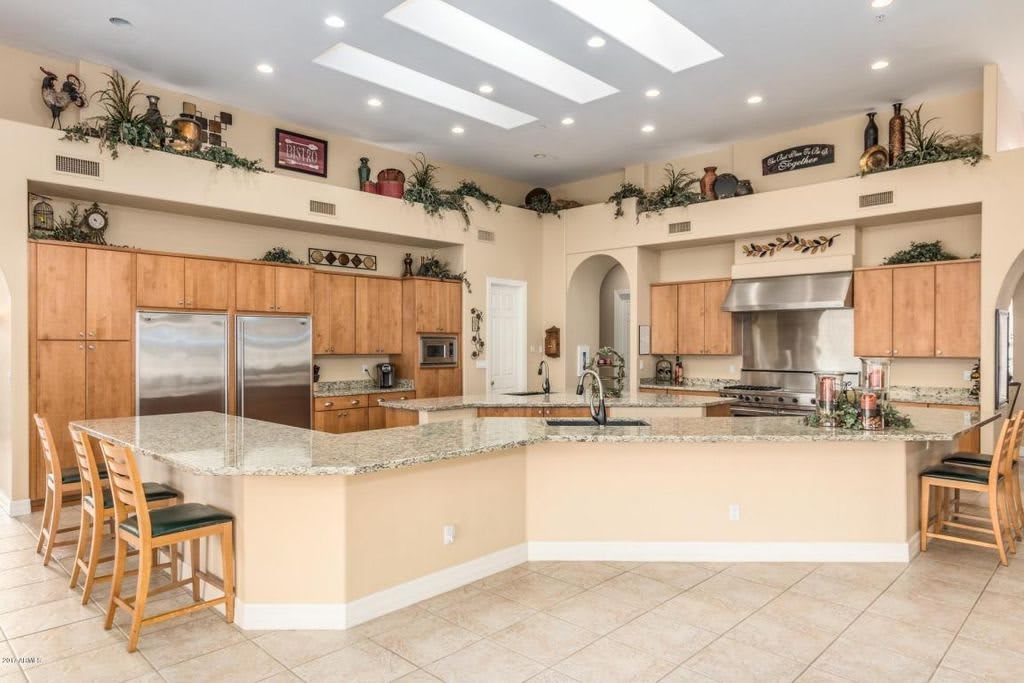 A large, modern kitchen with granite countertops and stainless steel appliances.