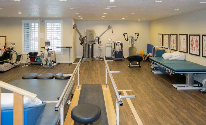 A well-equipped physical therapy and rehabilitation room with various exercise machines.