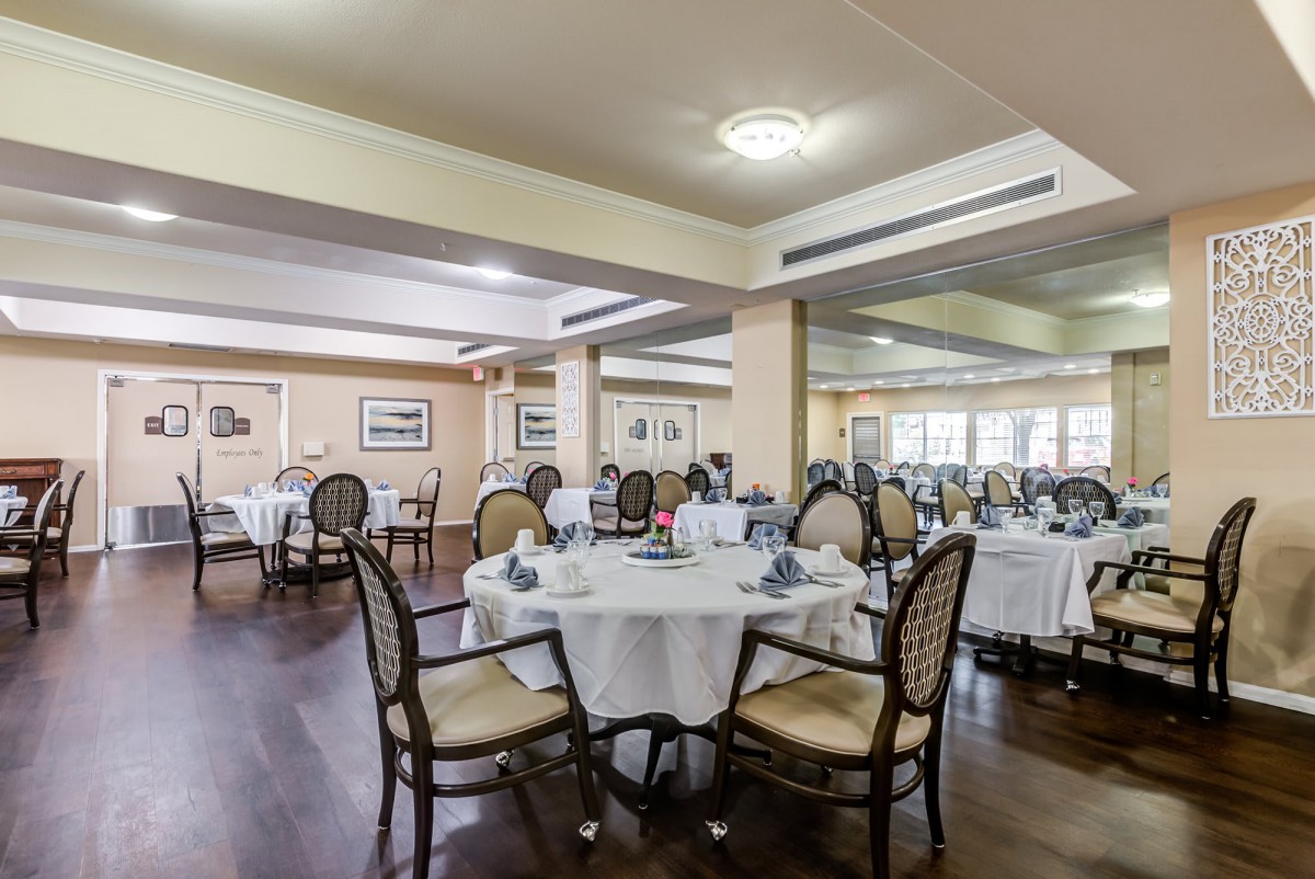 An elegant restaurant dining room with neatly arranged tables and chairs.