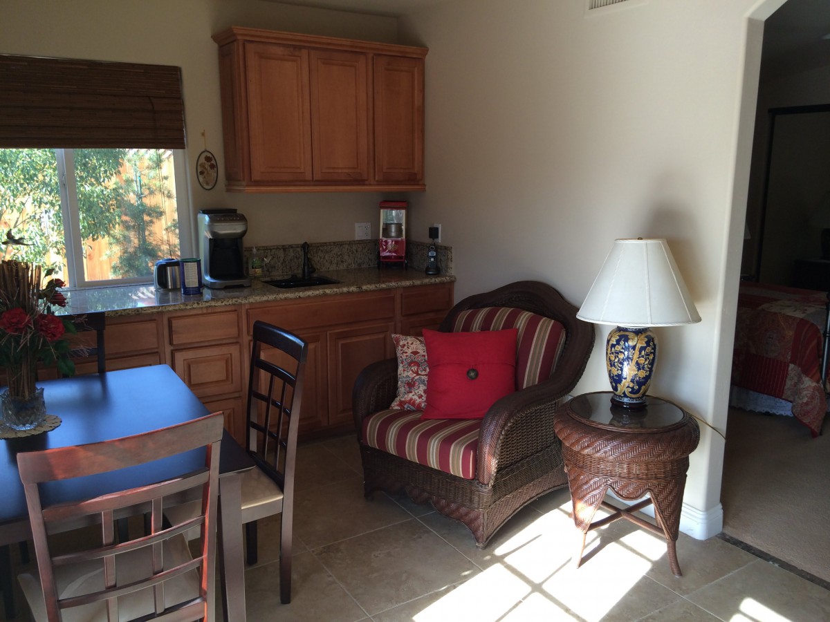 A cozy corner of a living space with a kitchenette and seating area.
