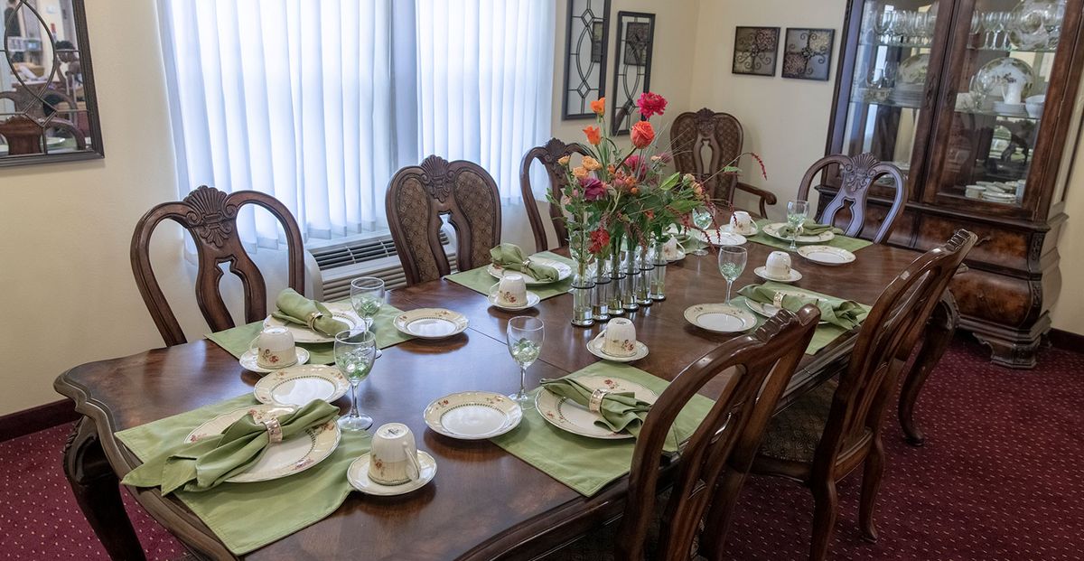 A beautifully set dining table with floral centerpiece and elegant place settings.