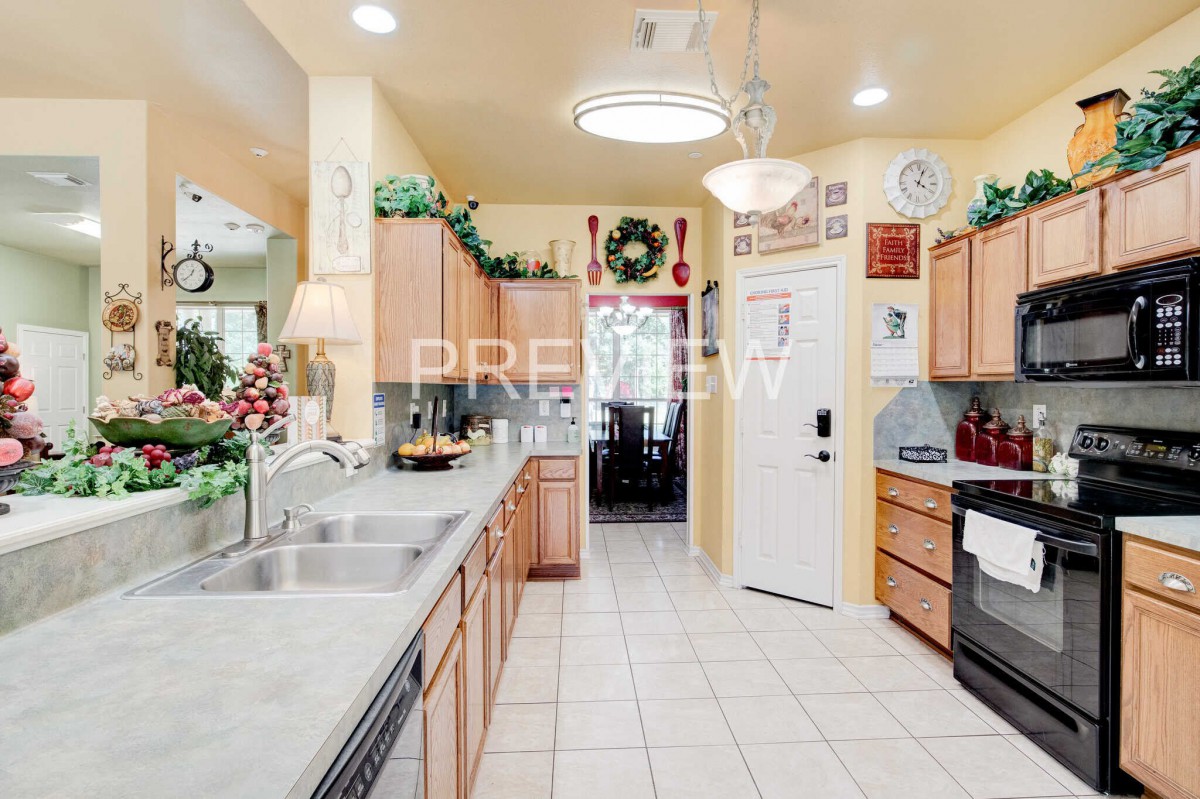 A bright and modern kitchen adorned with holiday decorations, featuring wood cabinets and a tile floor.