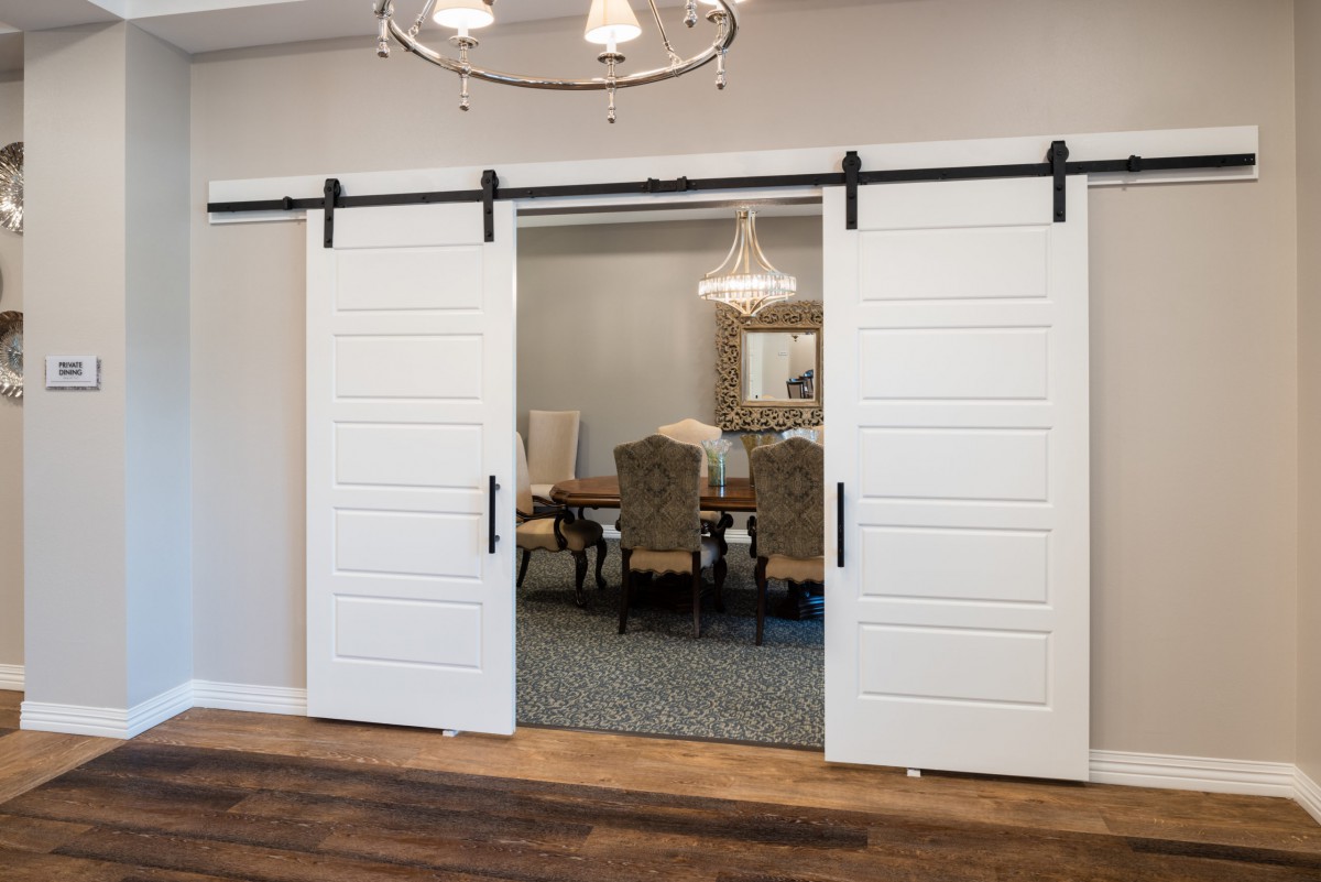 A modern dining room with white barn-style sliding doors.