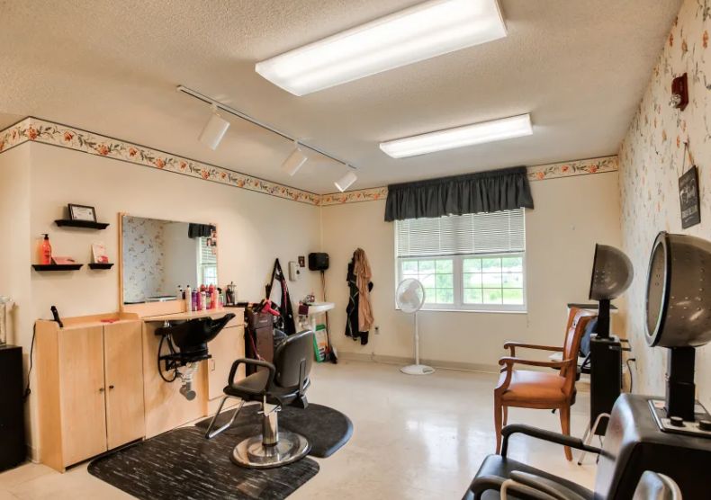 A well-lit hair salon interior with styling chairs and a large mirror.