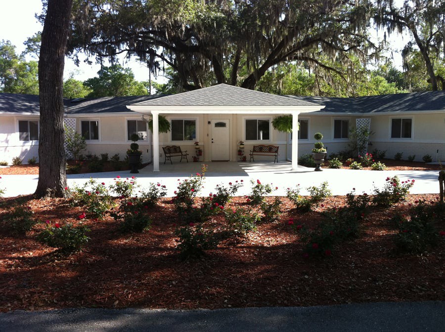 A charming single-story house with a well-maintained front yard and large tree.