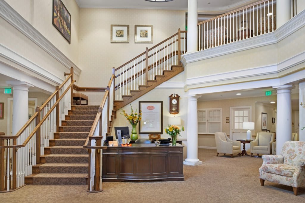 A spacious lobby with a staircase and reception area.