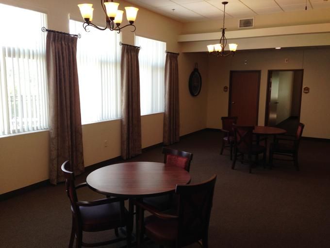 A quiet dining area with round tables, chairs, and soft lighting.
