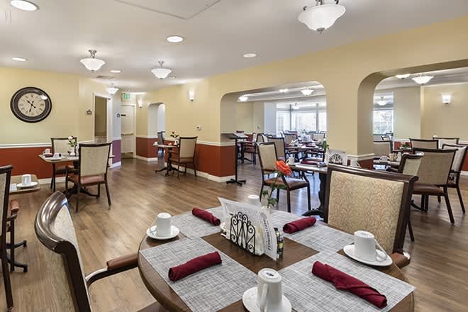 A well-arranged dining room with neatly set tables and ambient lighting.