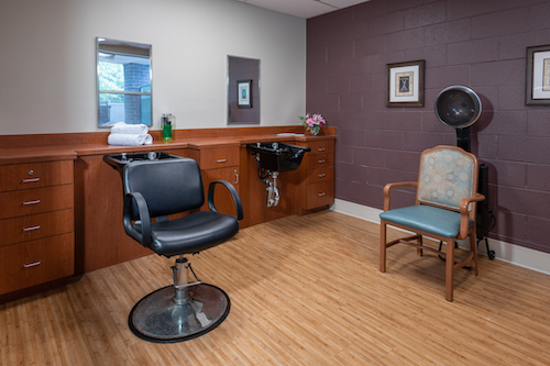 A modern hair salon showcasing a barber chair, wash station, and a comfortable waiting area.