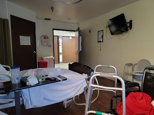 A hospital room equipped with a bed, walker, and television, conveying a clinical atmosphere.