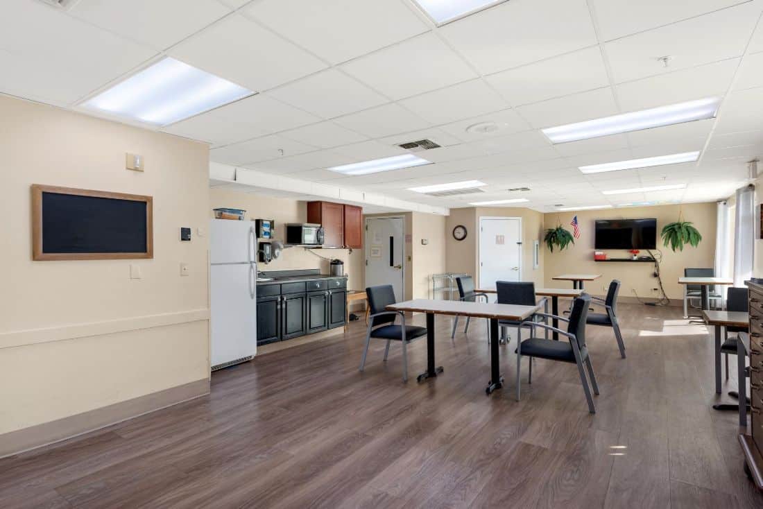 A modern community kitchen and dining area with tables and chairs.