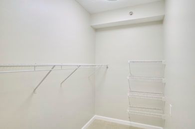 An empty closet with white walls and wire shelving.