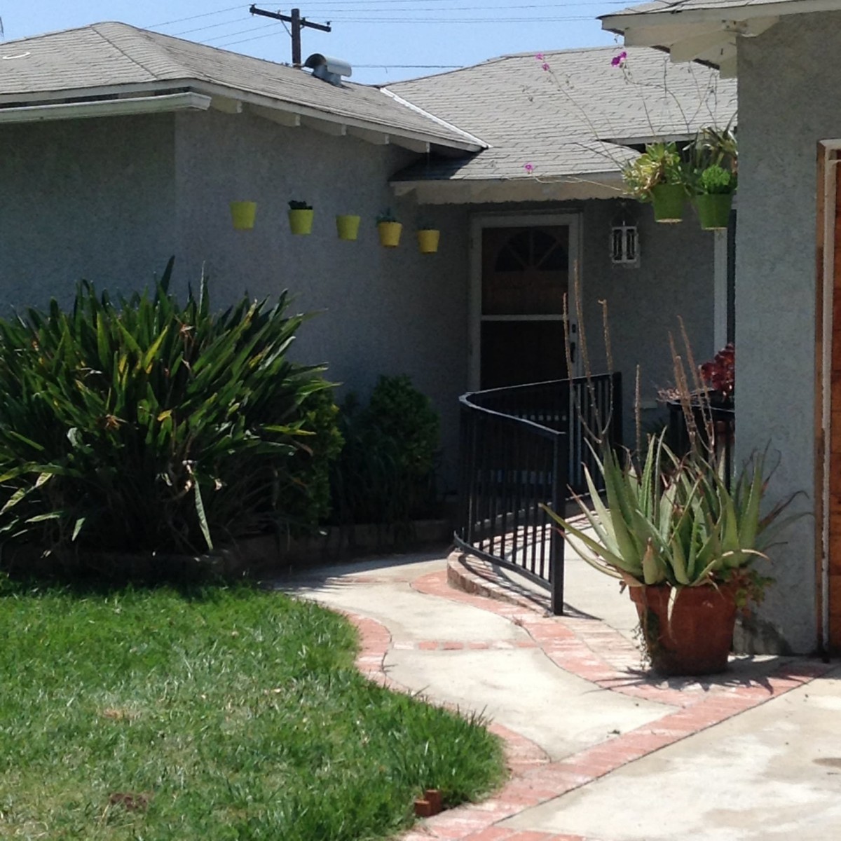 A residential house entrance with a small yard and pathway.