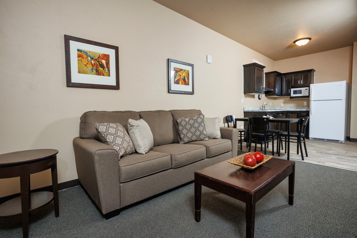A cozy living room with a sofa, coffee table, and adjoining kitchen area.