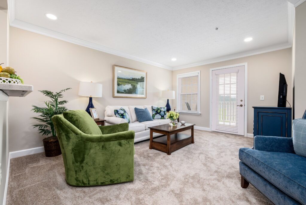A modern living room featuring a green armchair, plush sofa, and elegant decor.