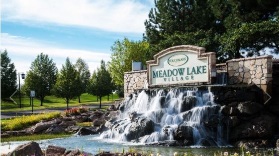 Entrance to Meadow Lake Village with a waterfall feature and landscaping.