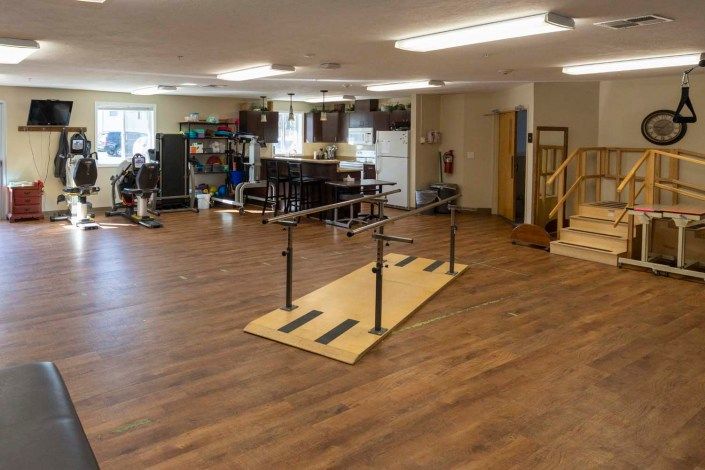 A rehabilitation clinic with various exercise equipment and therapy tools.