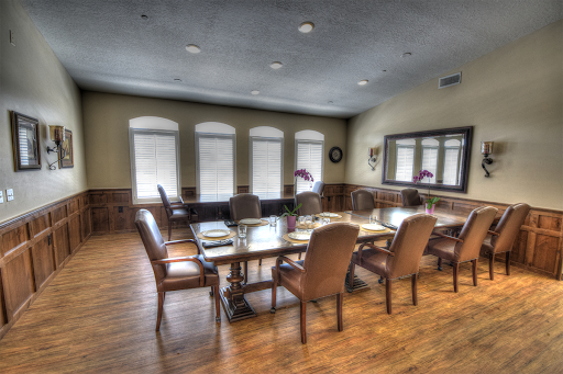 A well-lit conference room set up for a meeting, featuring a long table surrounded by comfortable chairs.