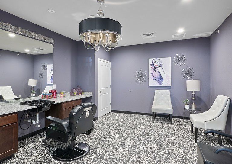 A stylish hair salon interior featuring a modern chandelier and barber chair.