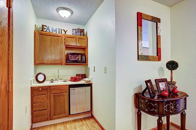 A cozy kitchen nook with wooden cabinets, a small sink area, and decorative accents.