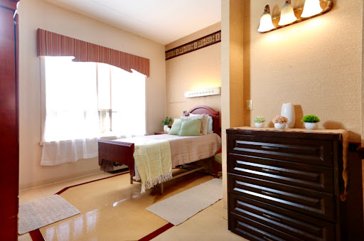A cozy and well-lit bedroom featuring a stylish bed, warm colors, and elegant decor.