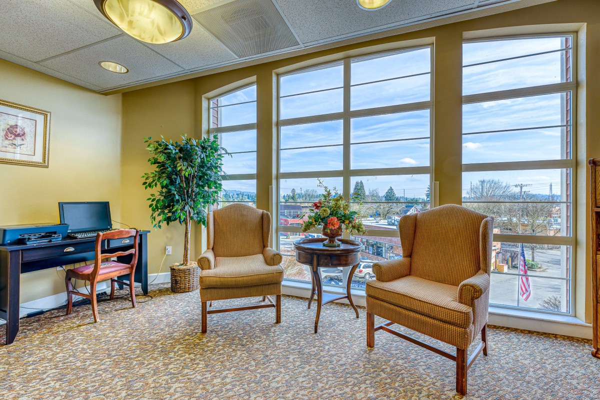 A cozy lobby area with comfortable chairs and large windows letting in natural light.