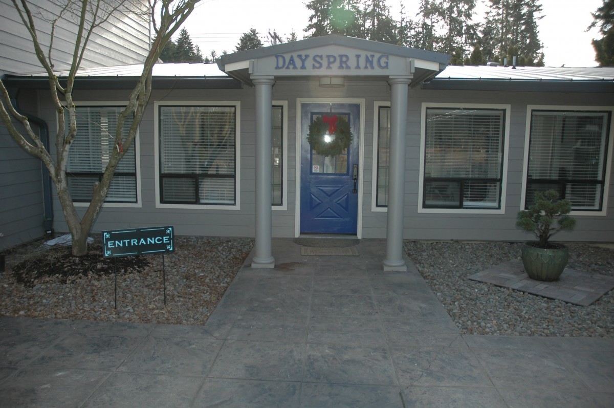 Front view of a building entrance with a blue door and pillars.