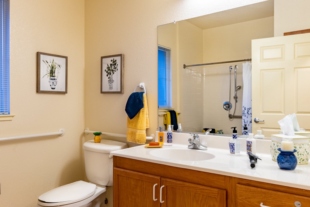 A well-organized bathroom with a sink, mirror, and shower.
