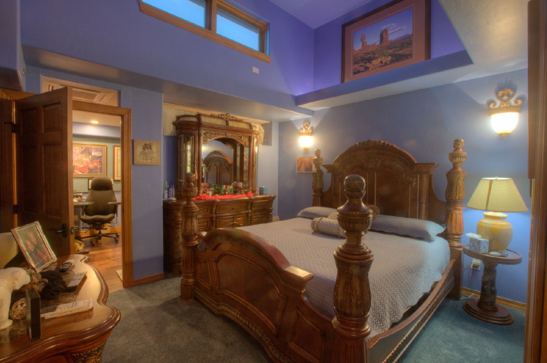 A luxurious bedroom with ornate wooden furniture and warm lighting.