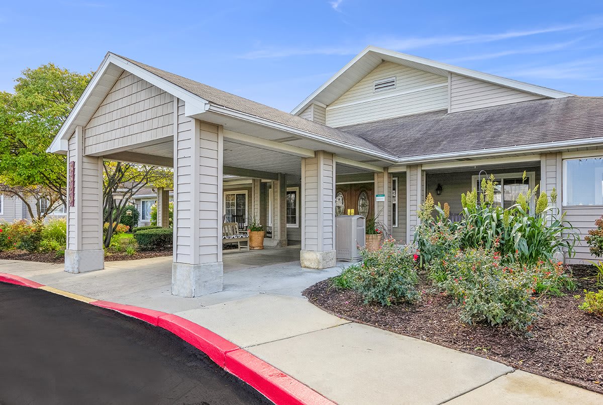 A residential building with a covered entrance and well-maintained landscaping.