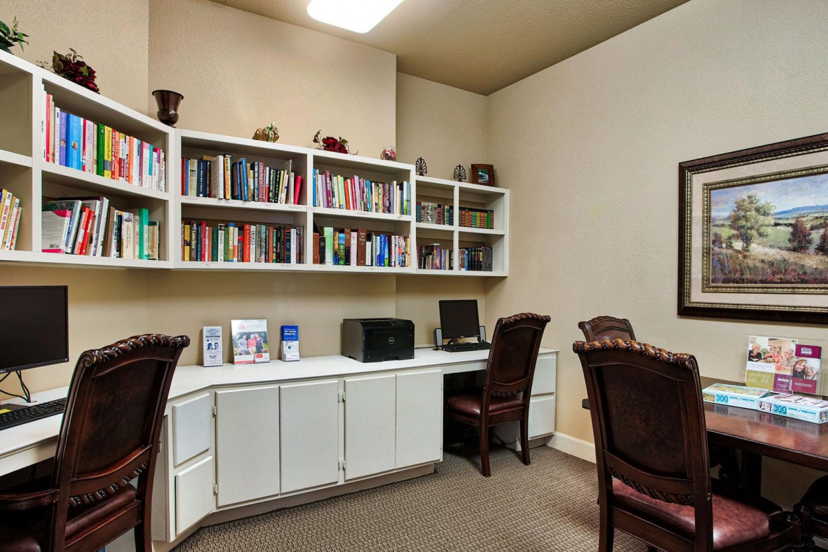 A tidy office space with bookshelves, a computer, and chairs.