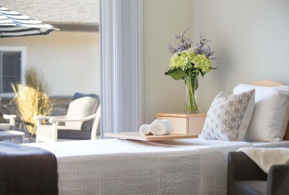 A cozy bedroom with a modern design, featuring a bouquet of flowers on the nightstand.