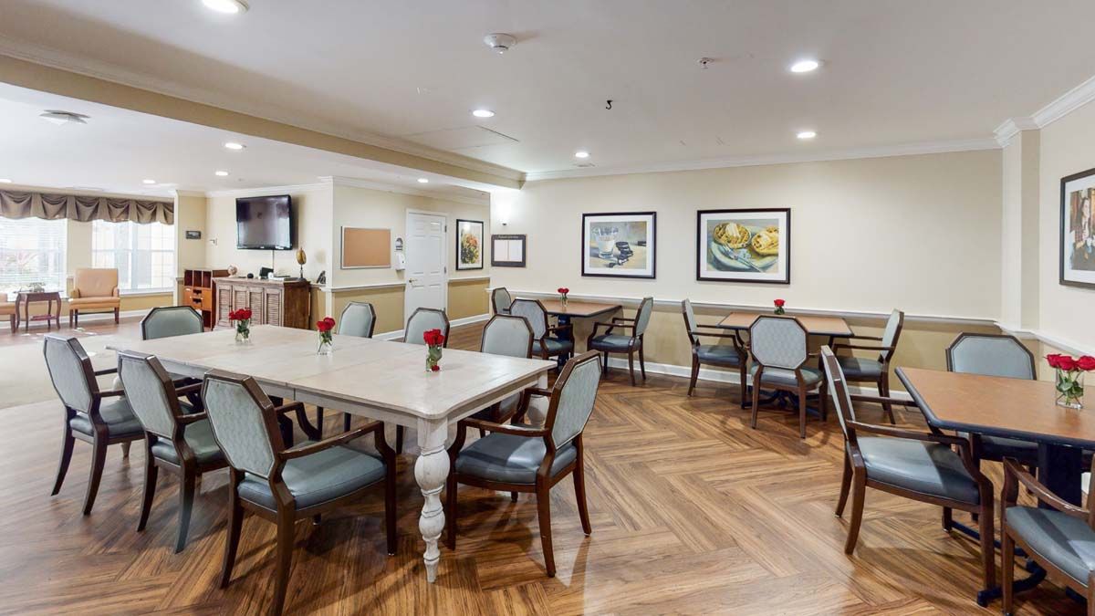 A well-lit dining area with multiple tables and chairs arranged neatly.